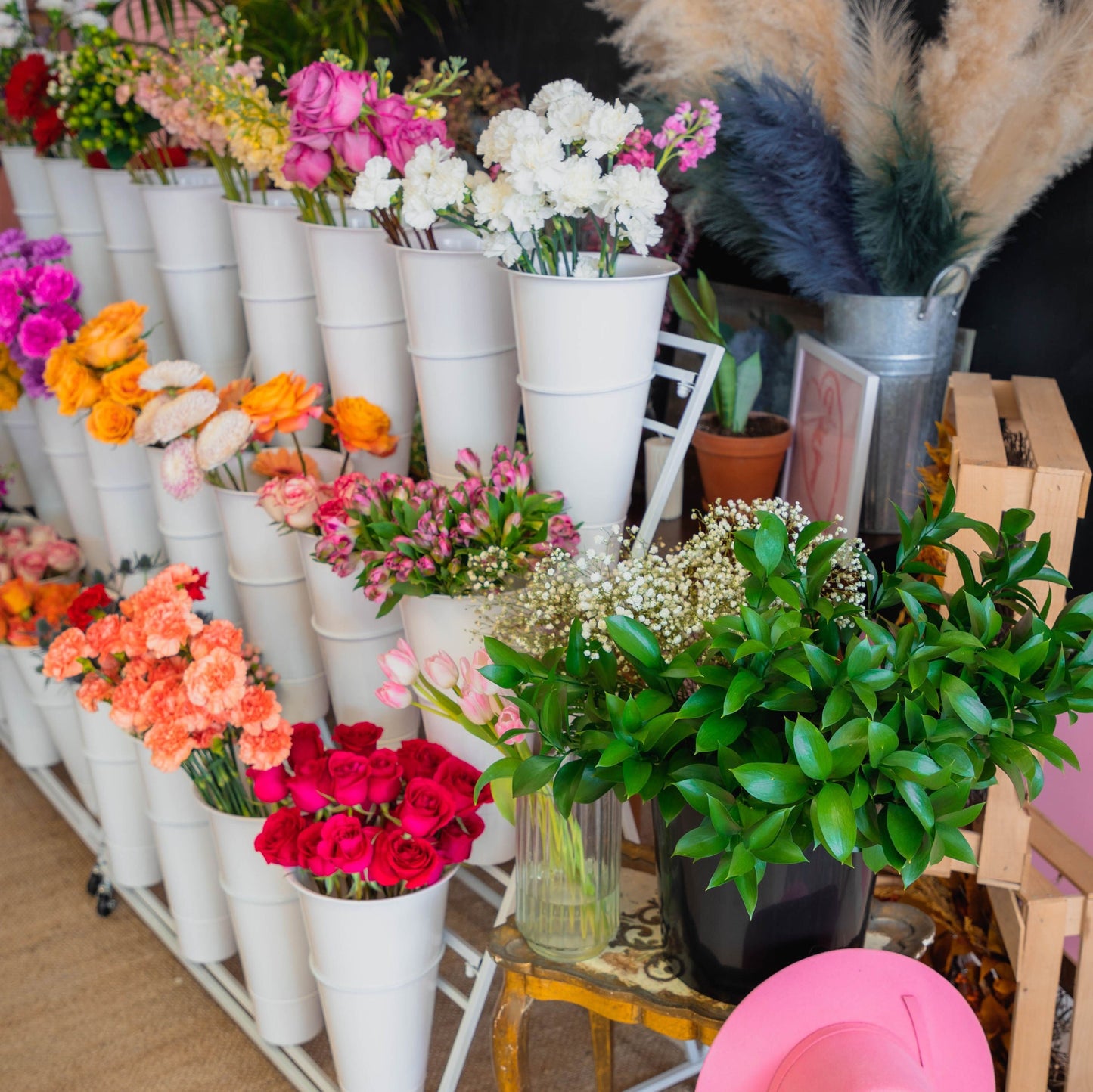 Colorful flower bar display with fresh seasonal blooms arranged in white buckets inside Fleur de Mer Flower Bar in Monmouth County NJ